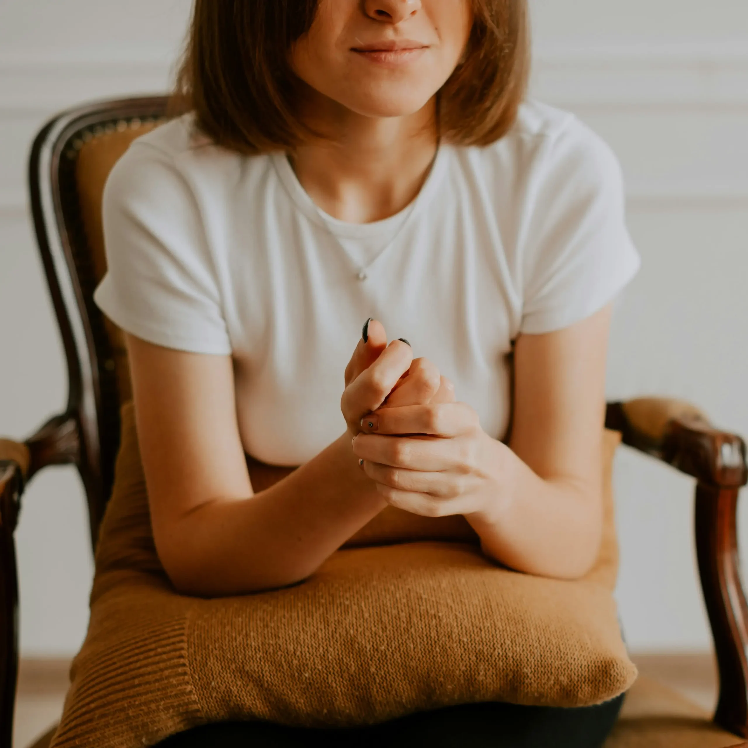 kateryna-hliznitsova-ycIdYuLIPR4-unsplash12 Person sitting with hands folded -symbolising calm and supportive autism-focused therapy